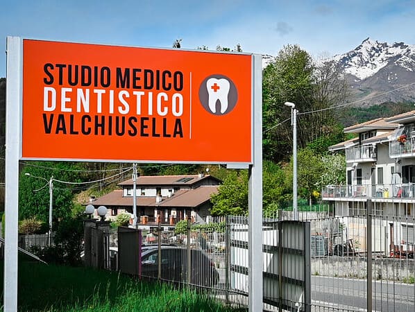 Il dentista spiega preventivo e pagamento rateale a un paziente arrivato da Ivrea